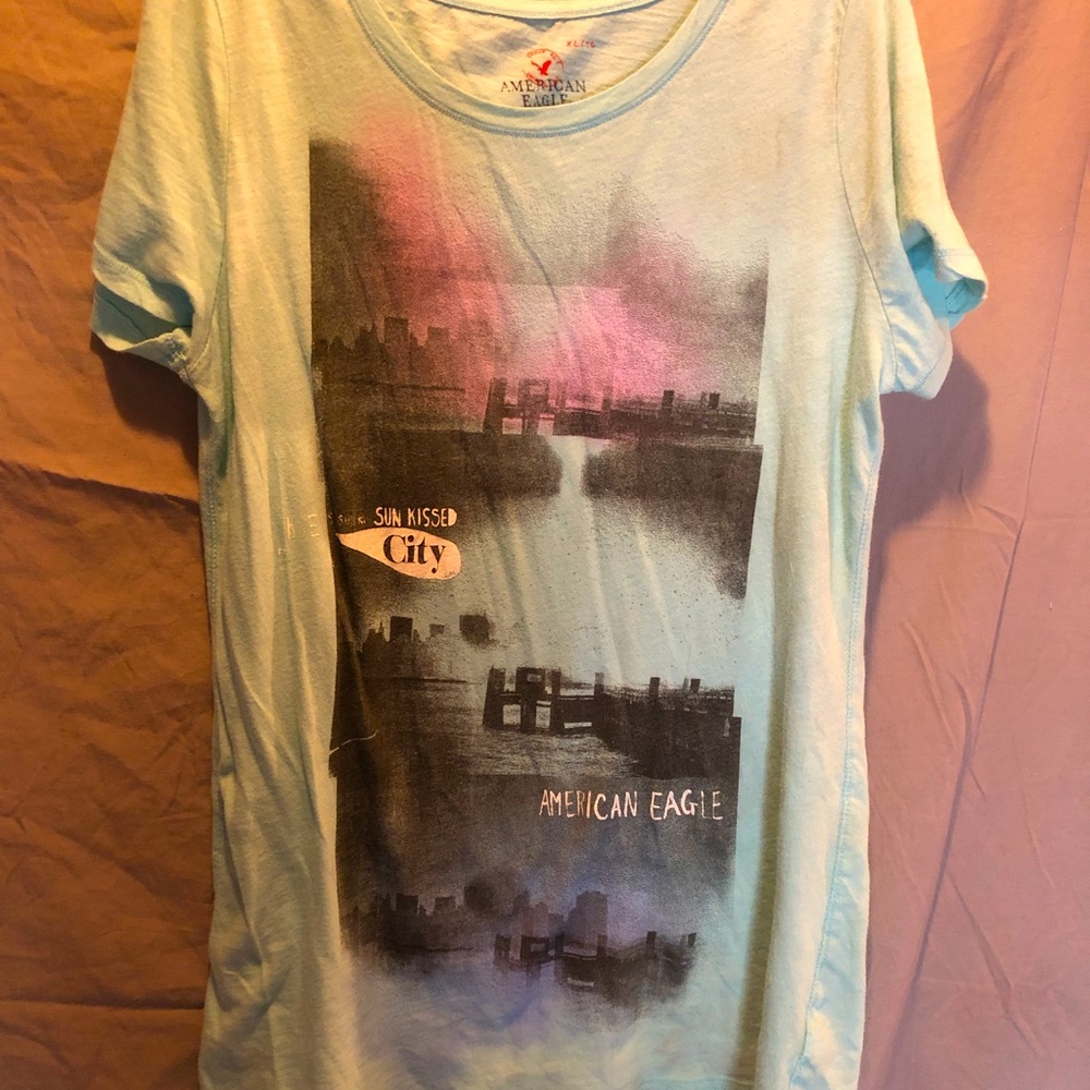 🦅CUTE👀American Eagle shirt the color is turquoise with sunrise/set